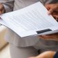 diverse business partners reading contract together 85x85